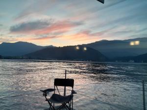 a chair sitting in the middle of a body of water at Botel Diffuso dei Laghi in Porto Ceresio +23 photos