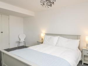 a bedroom with a white bed with white pillows at 11 Camden Building in Kendal
