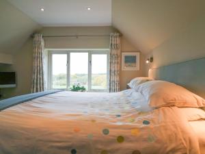 a bedroom with a large bed with a large window at Long Meadow in Heyshott
