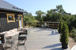 een houten terras met banken en een tafel en stoelen bij Pollin Piha in Töfsala