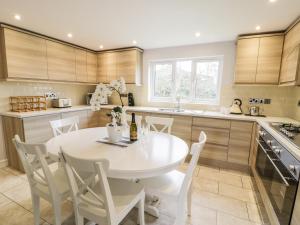 a kitchen with a white table and chairs at Nant Y Felin Lodge in Aberdaron