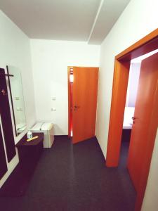 ブシュテニにあるHotel Paraul Receのオレンジ色のドアとトイレ付きのバスルーム