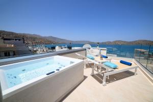 a hot tub on the balcony of a house at Naiades Village Elounda in Elounda