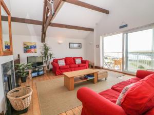 sala de estar con sofá rojo y mesa en Seascape en Holyhead