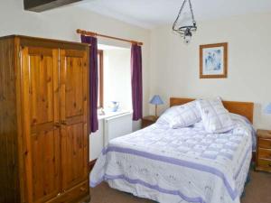 a bedroom with a bed and a window with purple curtains at The Carthouse in Newport