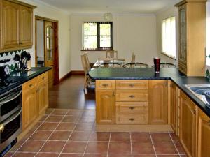 a kitchen with wooden cabinets and black counter tops at Llety'r Bugail in Dolgellau