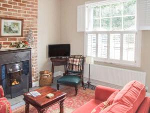 a living room with a couch and a fireplace at Woodland Cottage in Malvern Wells
