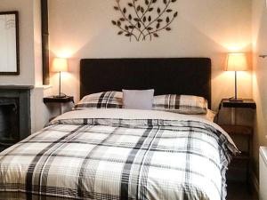 a bedroom with a bed with pillows and two lamps at Woodland Cottage in Malvern Wells