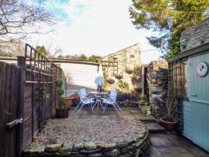 a patio with a table and chairs and a fence at Mill Cottage in Wolsingham