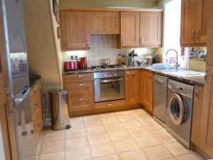 a kitchen with wooden cabinets and stainless steel appliances at Seascape in Buckie