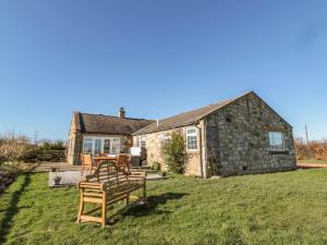 a house with a table and chairs in the yard at Thistleyhaugh Cottage in Morpeth