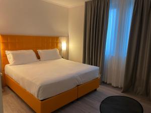 um quarto com uma cama grande e uma janela em Hotel Omnia em Noventa di Piave