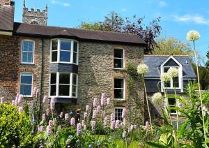 a house with purple flowers in front of it at Riverside Idyll - the perfect Cornish Sanctuary in Truro