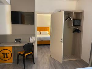a small room with a desk and a bed at Hotel Omnia in Noventa di Piave