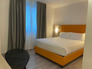 um quarto de hotel com uma cama e uma mesa em Hotel Omnia em Noventa di Piave