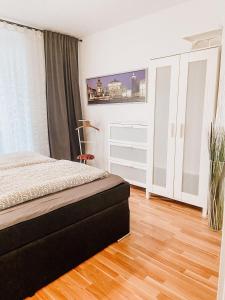 Schlafzimmer mit einem Bett und Holzboden in der Unterkunft Gemütliche FeWo mit Balkon in Leipzig