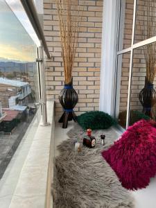 une terrasse avec un tapis et des vases sur une fenêtre dans l'établissement Lujoso Apartamento para Vacaciones y Negocios, à Cartago