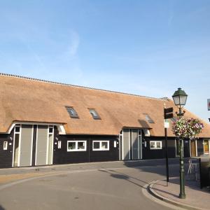 a building with a brown roof and a street light at Tin Tin in Cadzand, Koolse Hoeve 1b in Cadzand