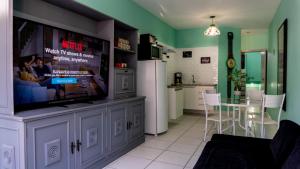 a living room with a tv and a kitchen at Duplex charmoso - Ótima localização in Rio de Janeiro