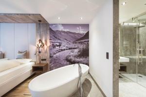 łazienka z wanną i sypialnia w obiekcie Mooshaus Winterresort w mieście Kühtai