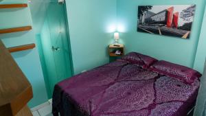 a bedroom with a purple bed and a picture on the wall at Duplex charmoso - Ótima localização in Rio de Janeiro +64 photos