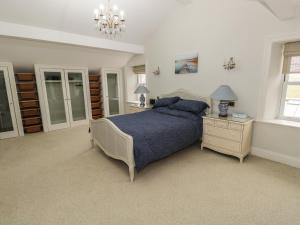 a bedroom with a bed and a night stand and a chandelier at Hillside Farm in Kirkby Stephen
