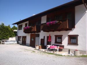 budynek z dwoma stołami i krzesłami przed nim w obiekcie Ferienhaus Eiter w mieście St. Leonhard im Pitztal