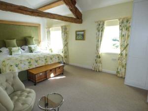 een slaapkamer met een bed, een tafel en een bank bij Kestrel Cottage in Grange Over Sands