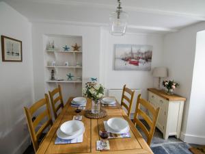 a dining room with a wooden table and chairs at Eddystone Cottage in Wadebridge