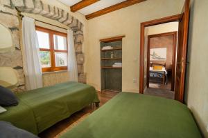 a bedroom with two green beds and a window at House Luce in Krapan