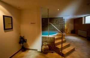 - une salle de bains avec baignoire dans une chambre avec escalier dans l'établissement Hotel Martinerhof, à San Lorenzo di Sebato