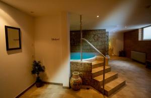 a bathroom with a bath tub in a room with stairs at Hotel Martinerhof in San Lorenzo di Sebato