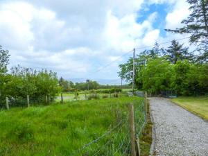 a fence in the middle of a field with a grass field at Ferrys in Portsalon