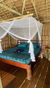 a bed in a room with a canopy at Nyande Raja Ampat in Pulau Mansuar