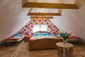 a attic bedroom with a bed and a table at Villa Magonīte in Ventspils