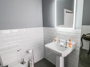 ein weißes Badezimmer mit Waschbecken und Toilette in der Unterkunft Angel Cottage in Skipton + 18 Fotos