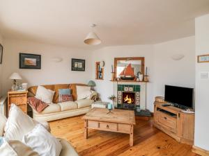 sala de estar con sofá y chimenea en Driftwood Cottage, en Fethard-on-Sea