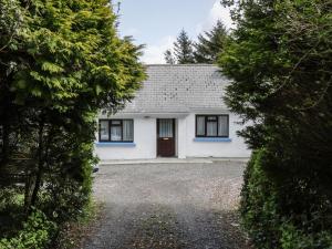 a white house with blue windows and a driveway at Killary Bay View House in Renvyle