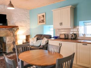 a kitchen with a table and a living room at Mary Larkin's Cottage in Lisnacree