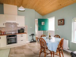 羅斯特雷弗的住宿－Pat White's Cottage，一间厨房,里面配有桌椅