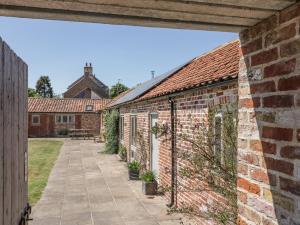 an external view of the courtyard of a brick building at Cow Byre in Great Habton
