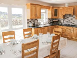 a kitchen with a white table with chairs and a table at Lakeview in Lettermore