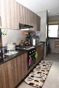 une cuisine avec cuisinière et tapis de cuisine dans l'établissement Appartement, à Temara