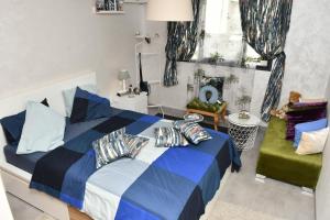 - une chambre avec un lit bleu et blanc et un canapé dans l'établissement Appartement, à Temara