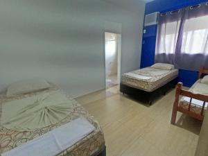 1 Schlafzimmer mit 2 Betten und einem Spiegel in der Unterkunft Hotel Mão de Fatima in Aparecida