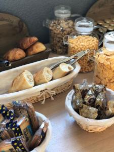a table with baskets of bread and pastries on it at Enzo Hotels Neufchâteau by Kyriad Direct in Neufchâteau