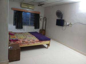 ein Schlafzimmer mit einem Bett in einem Zimmer in der Unterkunft Lakshmi cottage in Mahabalipuram