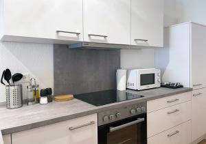 a kitchen with a microwave and a stove top oven at Schönes Apartment im Herzen von Melle I home2share in Melle +9 photos