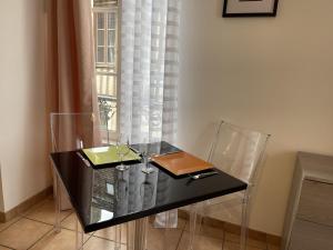 - une table en verre avec des verres à vin et une fenêtre dans l'établissement Appartement le Paul Bert Auxerre Les Quais 2 personnes, à Auxerre