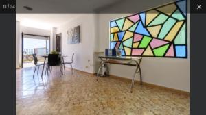 Habitación con mesa y vidriera. en Apartamento Carihuela Primera Linea Playa en Torremolinos